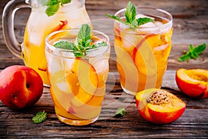 Summer cold drinks: homemade peach sangria with ice cubes, and mint in glasses