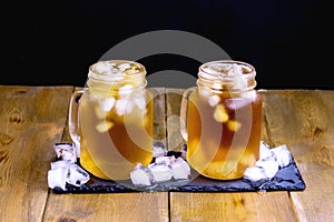 Summer Cold Ice Tea with Citrus and Ice Cube in Glass Jar Wooden Background Close Up Cold Summer Beverage