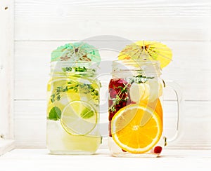 Summer cold infused lemonade with fruits and berries in glass jars