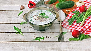 Summer cold kefir soup in glass bowl with spicy herbs