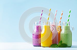 Summer colorful fruit smoothies in jars on blue background. Healthy, detox and diet food concept