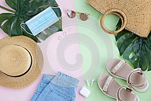 Summer composition with female fashion outfit. Monstera leaves, straw hat, bamboo bag, shoes, wireless headphones on