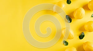 Summer composition made from lemon and green leaves on pastel yellow background. Fruit minimal concept. Flat lay, top view