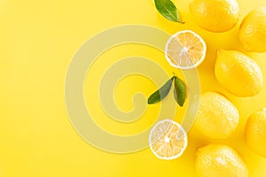 Summer composition made from oranges, lemon and green leaves on pastel yellow background. Fruit minimal concept. Flat lay, top