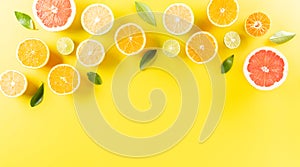 Summer composition made from oranges, lemon or lime on pastel yellow background. Fruit minimal concept. Flat lay, top view