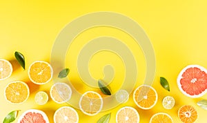 Summer composition made from oranges, lemon or lime on pastel yellow background. Fruit minimal concept. Flat lay, top view