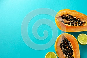 Summer composition. Tropical lime and papaya fruit cut in half lie on a blue background. Summer concept. Flat lay, top
