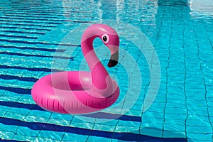 Summer concept background. Pink inflatable flamingo in pool water for summer beach background. Pool float party