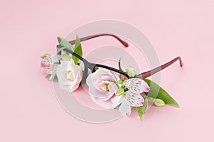 Summer concept of beach sunglasses with flowers instead of glasses on a pink background. Summer vacation and enjoyment