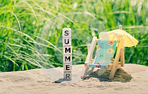 Summer concept. Dice placed on a beach form the word `summer`