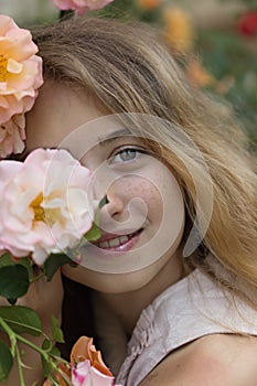 Summer concept. Smiling teenager girl posing with pink and orange roses