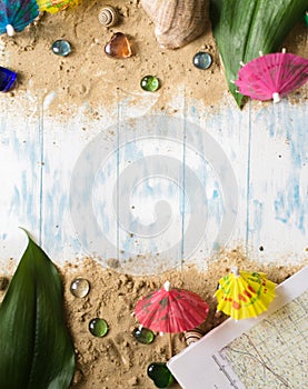 Summer concept. Umbrellas for cocktails on sand on a wooden background with pebbles