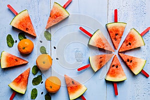 Summer concept watermelon slice popsicles on a blue rustic wood