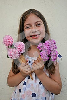 Summer concept with young girl eating a flower cone
