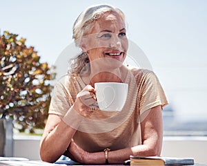 Summer contemplation. an attractive senior woman enjoying her breakfast while sitting outside on the balcony at home.