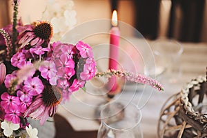 Summer cottage kitchen decorated for festive dinner. Romantic table setting with candles and flowers