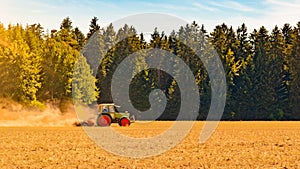 Summer countryside / agriculture harvest forest background banner panorama: old tractor milling straw grain barley wheat field,