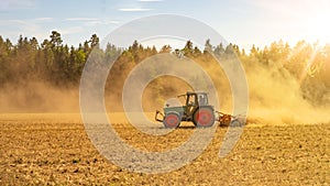 Summer countryside / agriculture harvest forest background banner panorama: old tractor milling straw grain barley wheat field,