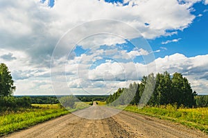 Summer countryside nature landscape. Blue sky white clouds green meadows rural road. Horizontal frame