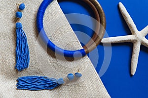 Summer creative composition of modern female vacation outfit closeup. Beautiful lady`s holidays accessories on blue color