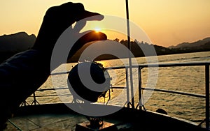 Summer cruise vacation concept. Silhouette view of the sea with a beautiful sunset just above the horizon touch the sun with