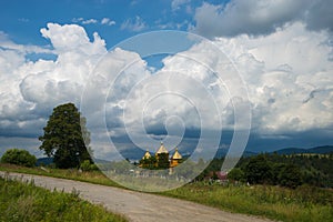 Summer day landscape with forest, cloudy sky and road.