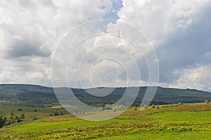 Summer day landscape with road, cloudy sky and small houses. Ukraine, Carpathian.