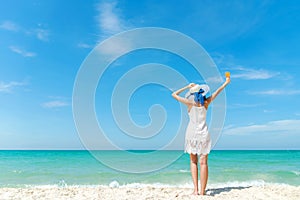 Summer Day. Lifestyle  woman wearing white dress fashion summer beach  on the sandy ocean beach. Happy woman enjoy and relax vacat