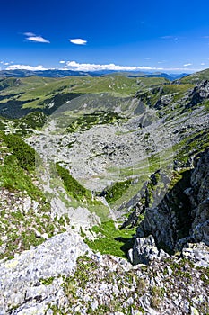 Summer day mountain landscape. Green rocky mountains and a blue sky. The Parang Mountains, Romania