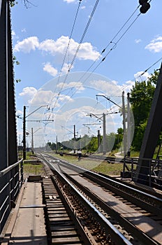 Summer day railway landscape with a view from the railway bridge to the suburban passenger statio