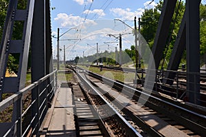 Summer day railway landscape with a view from the railway bridge to the suburban passenger statio