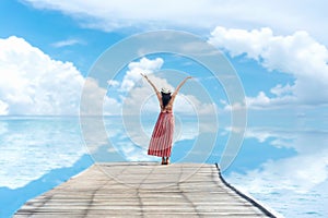 Summer Day. Smiling women relax and wearing red dress fashion standing on the wooden bridge