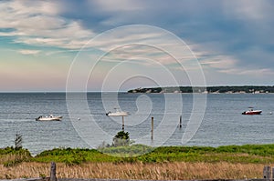 The amazing view  of the ocean, small boats and colorful cloudy sky. Tisbury, MA