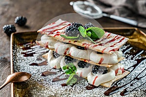 Summer dessert with berries and custard cream, decorated with mint on plate on wooden table. Delicious dessert and candy bar,