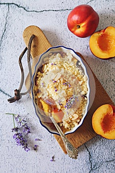 Summer dessert. Fresh peach crumble, almonds petal and lavender