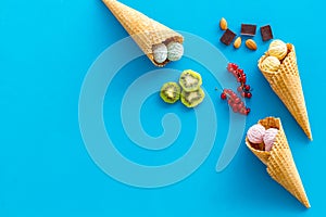 Summer dessert with ice cream in cones on blue backgroung top view mock up