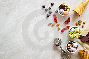 Summer dessert with ice cream, cones, chocolate, berries and nuts on marble backgroung top view mockup