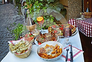 Unidentified people eating traditional italian food in outdoor restaurant in Trastevere district