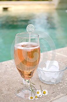 Summer drink in a glass near the swimming-pool