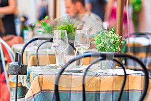 Summer empty open air restaurant in Vatican city in Italy. Closeup wineglasses on the table