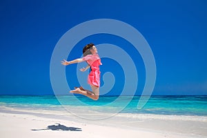 Summer enjoyment. Happy young woman jumping on the sea, brunette