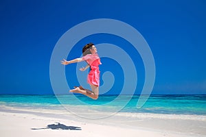 Summer enjoyment. Happy young woman jumping on the sea, brunette photo