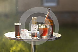 Summer evening. Colored drinks in various glassware on the outdoor table, a party in the backyard house with cold drinks, A set