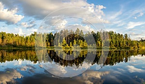 Summer evening landscape on Ural lake with pine trees on the shore, Russia