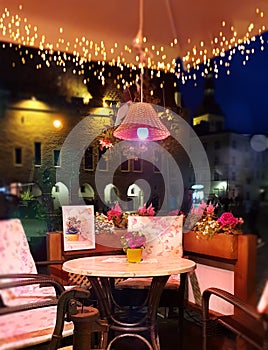 Summer Evening Lighting illumination Street Cafe decoration Table with flowers on top And Lamp Restaurant outdoor in the city rela