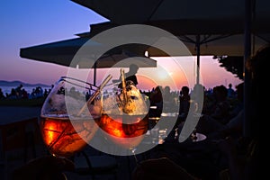 Summer evening orange cocktail in a bar by the sea at the sunset