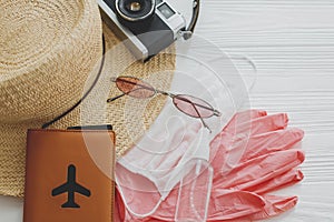 Summer 2020. Face mask, pink gloves, antiseptic and disinfectant, passport, sunglasses, straw hat on white background. Safe travel