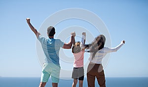 Summer family. Back view of happy young family walking on beach. Child with parents holding hands. Full length poeple.