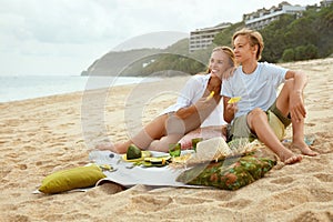 Summer. Family Picnic On Beach. Portrait Of Young Woman With Son Enjoying Lunch At Tropical Ocean.