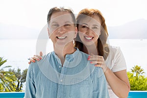 Summer family vacation. Happy middle aged couple having fun on travel holidays weekend. Sea and beach background. Copy space